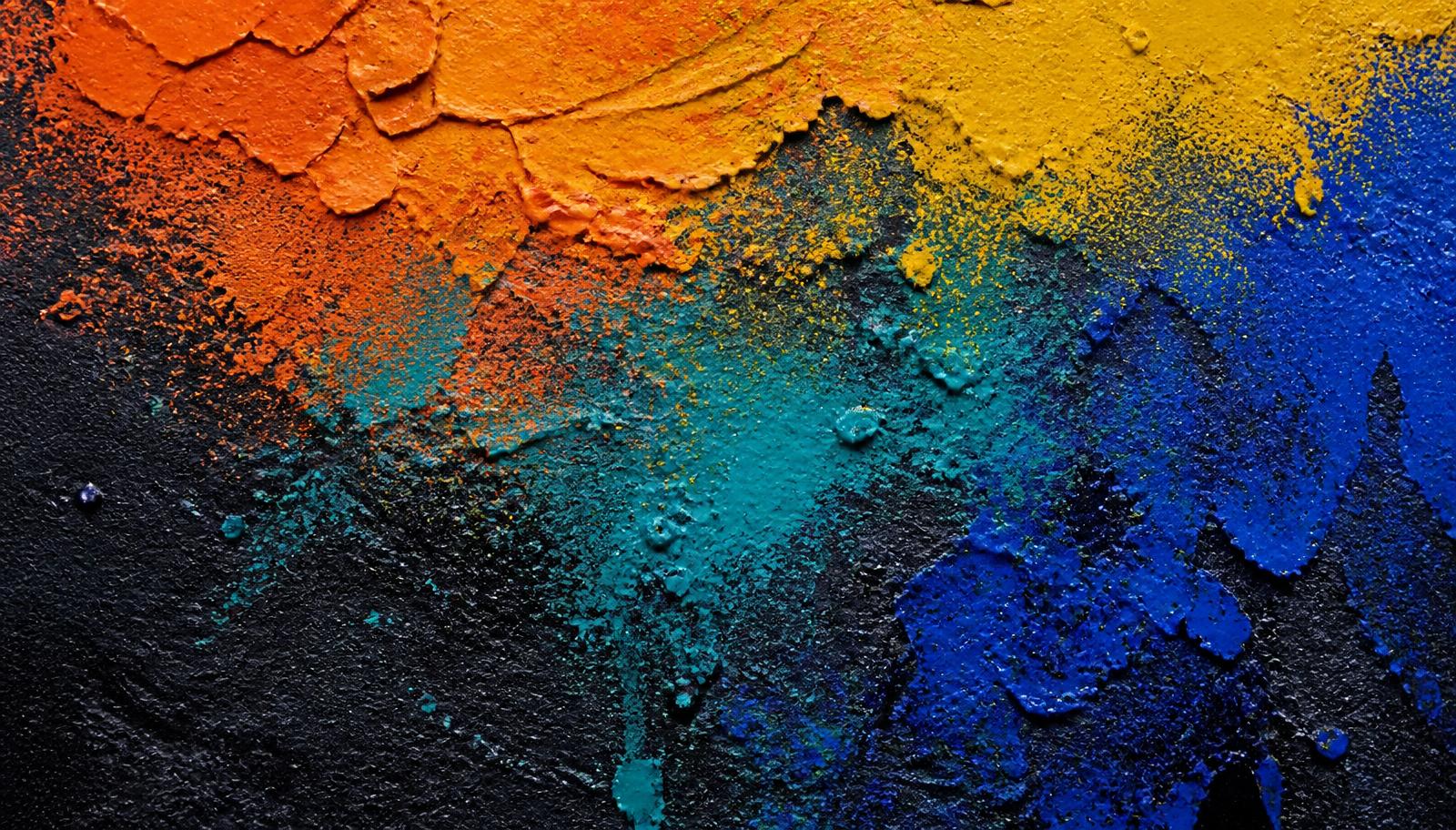 Layered spray paint texture in orange, yellow, teal and cobalt